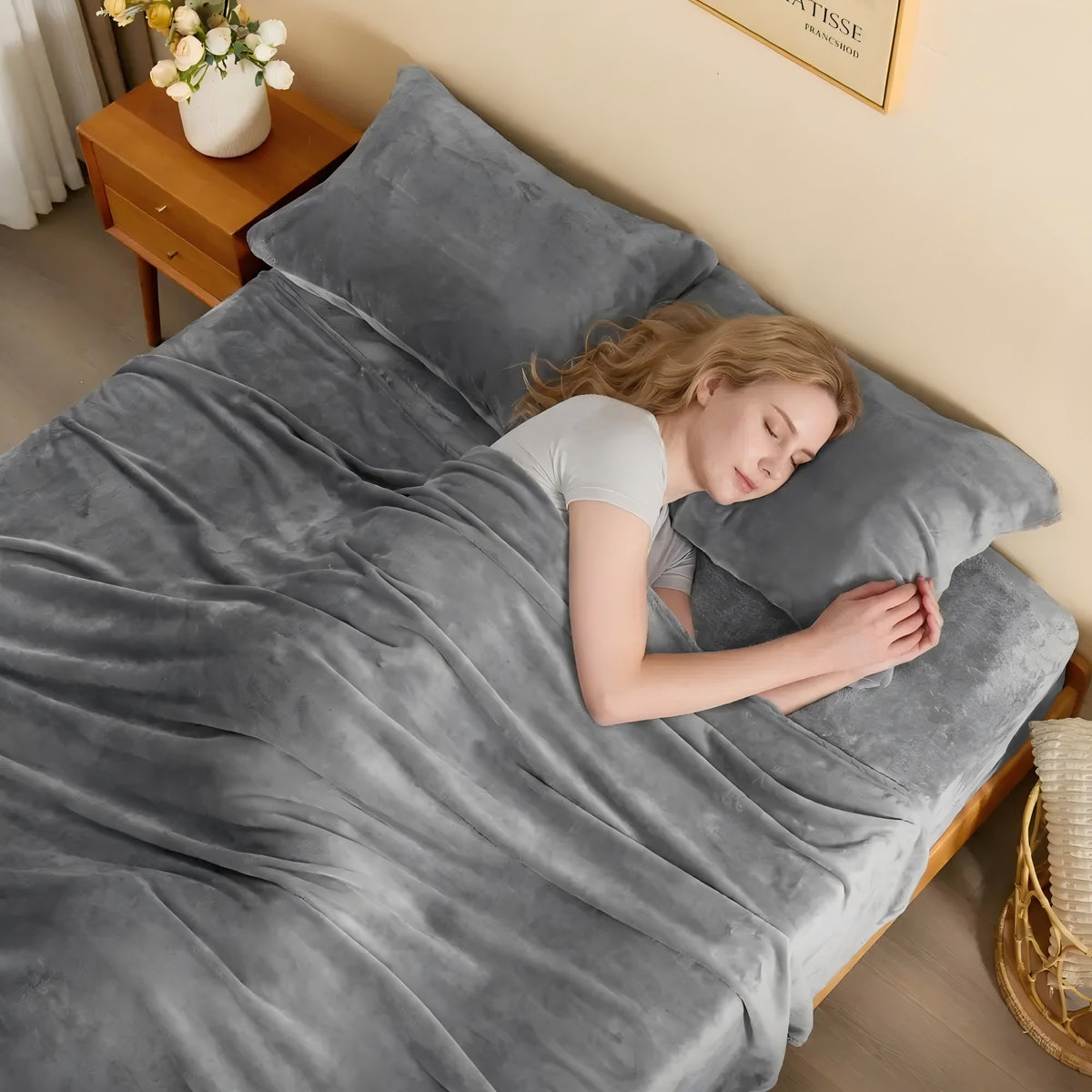 Woman sleeping comfortably in bed with Bedelite warm grey fleece sheet set and plush pillowcases