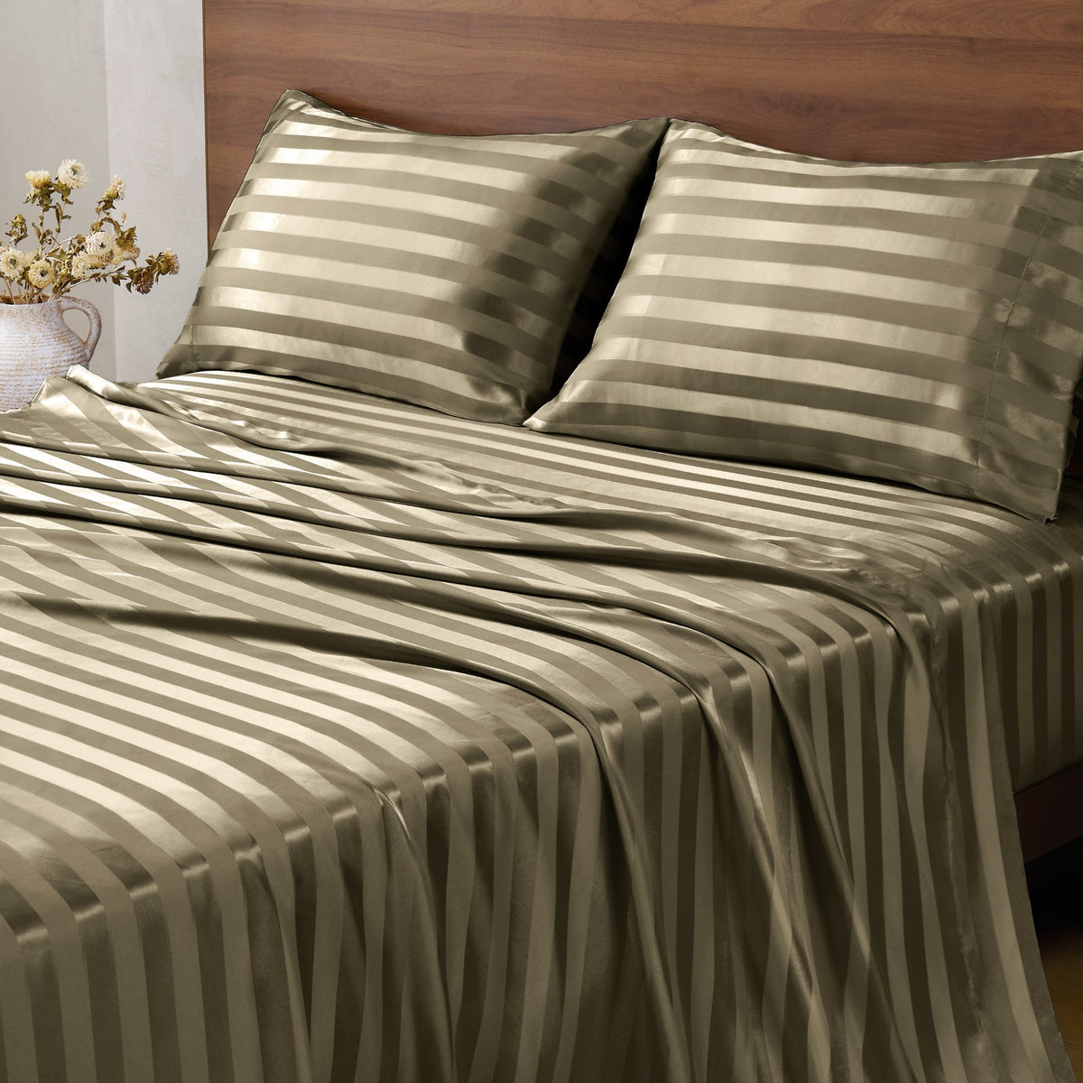 Olive green striped bed sheets and matching pillowcases on a bed with a wooden headboard