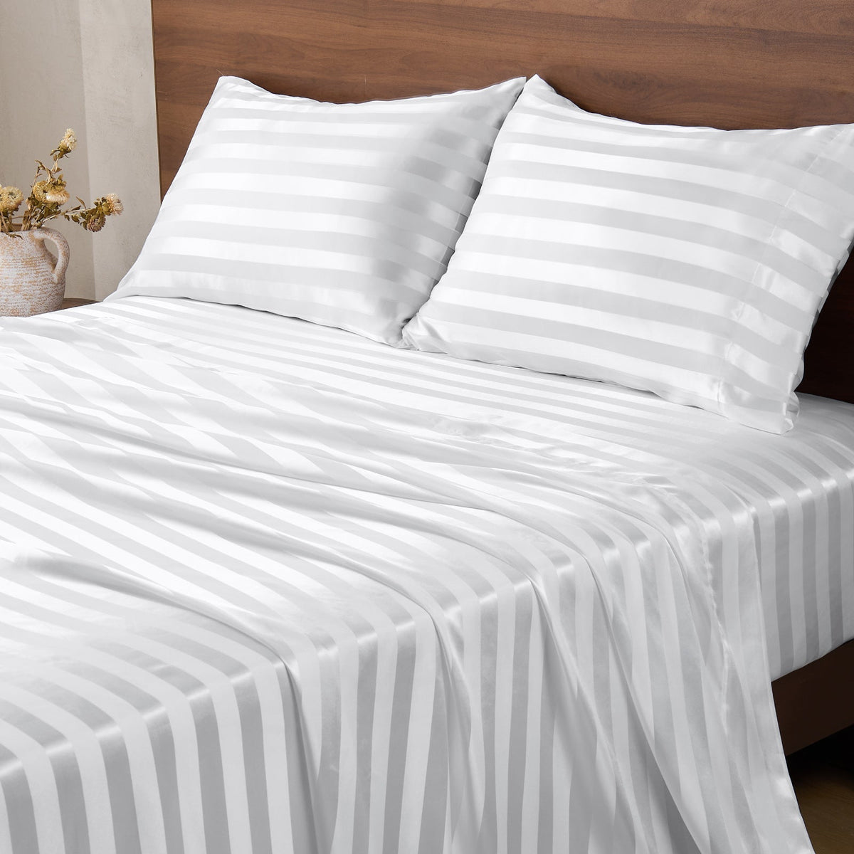 White striped bed sheet set with matching pillowcases on a bed