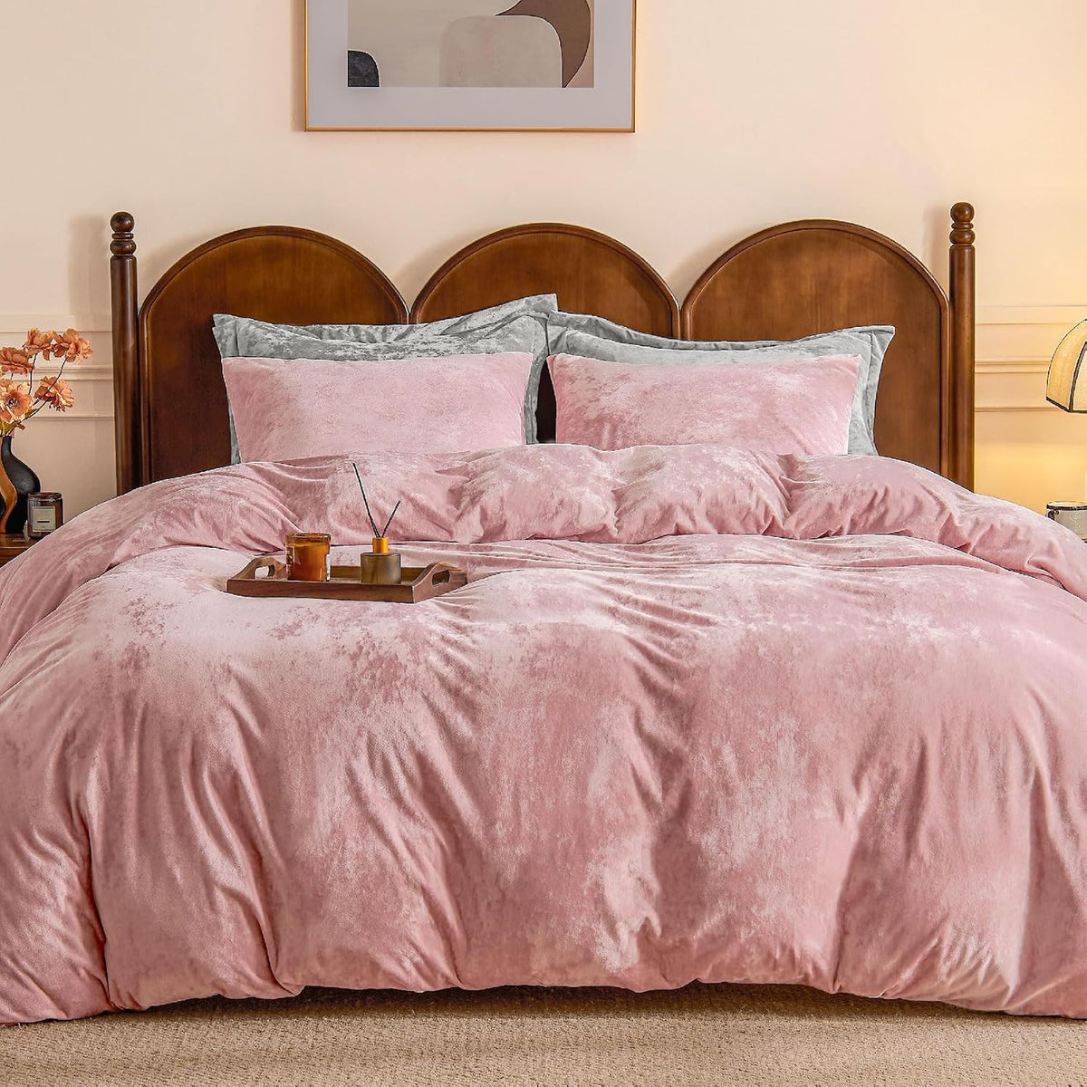 Dusty pink velvet duvet cover on a queen bed with matching pillows and a wooden headboard